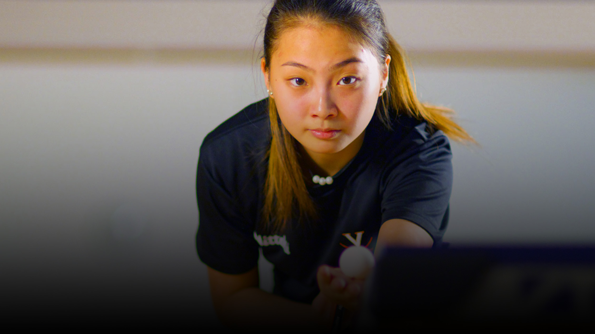 Portrait of a UVA girl playing table tennis.