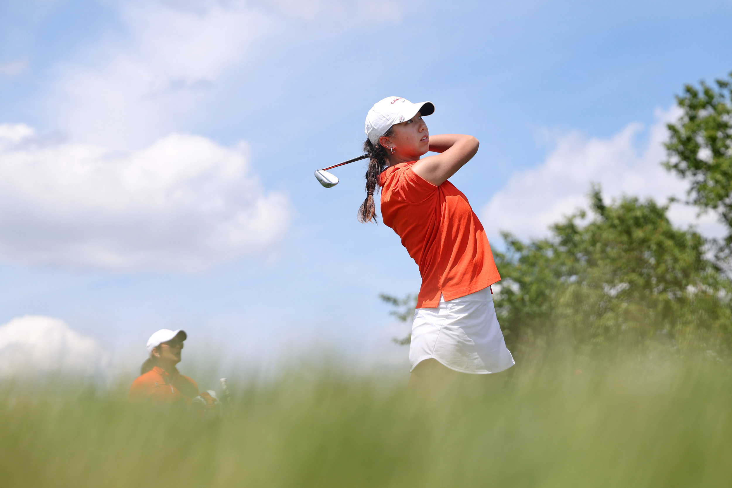 Looking up from the grass at Jaclyn LaHa after a big golf swing