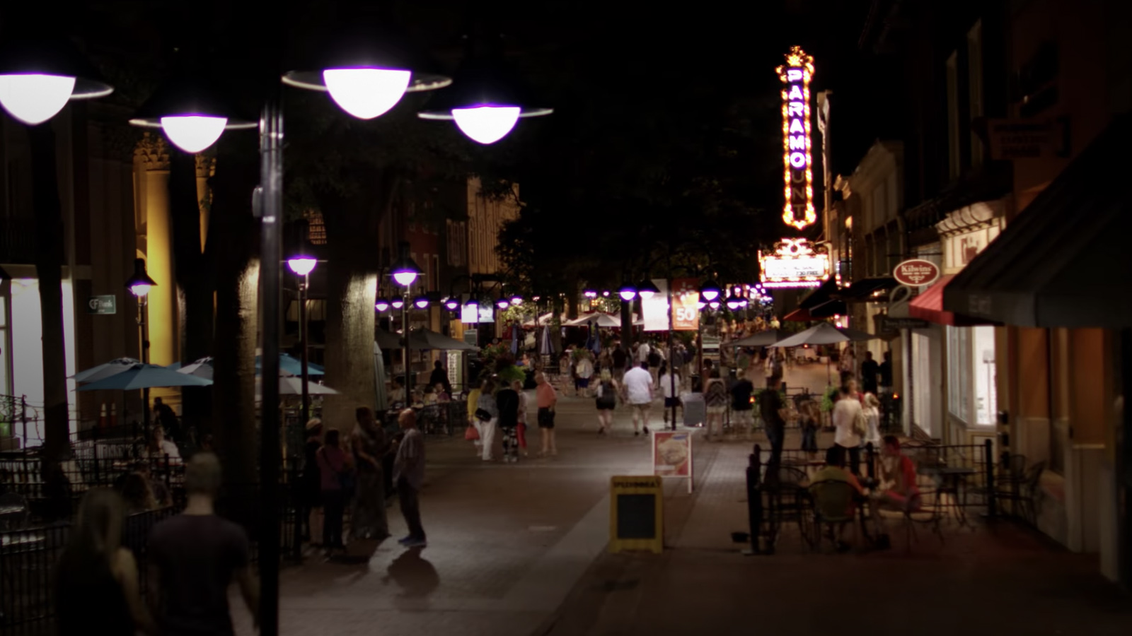 Portrait of downtown Charlottesville in night with people.